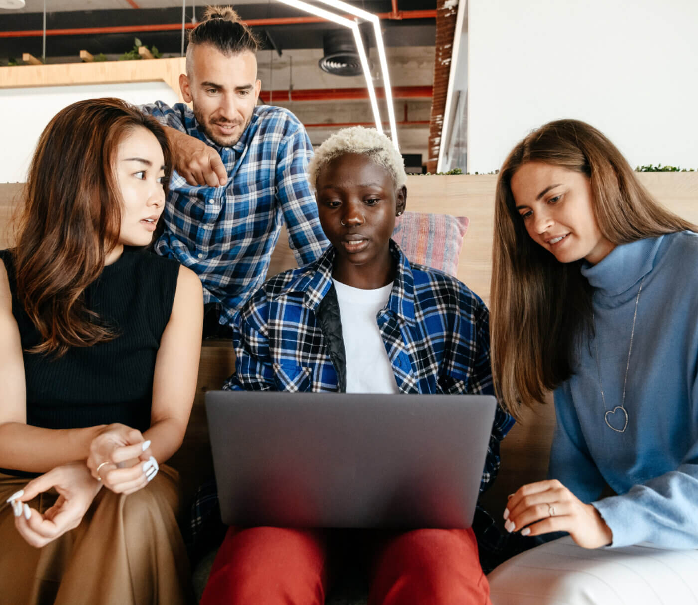 Group of employees looking at a laptop computer screen together 