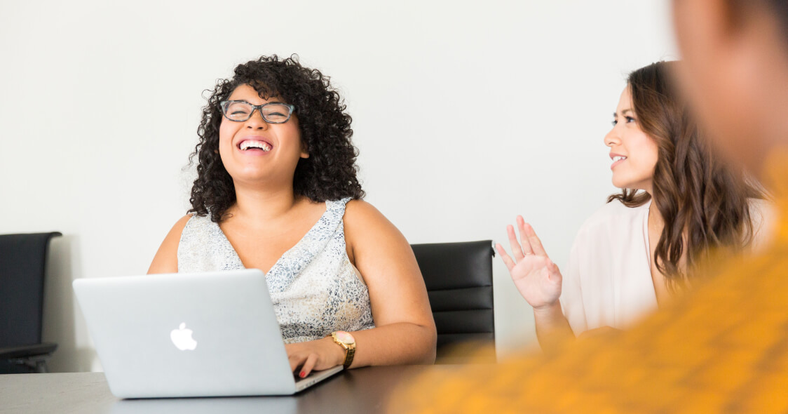 Woman smiling at her laptop during a meeting