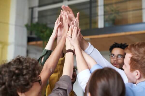 Group of people giving a high five in the middle of the group