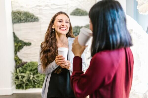 Two girls having coffee together and smiling