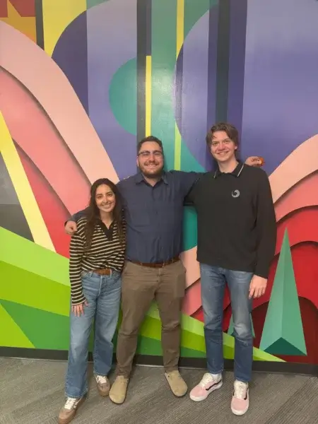 Group of 3 Denver IT staffing team members standing in front of colorful wall